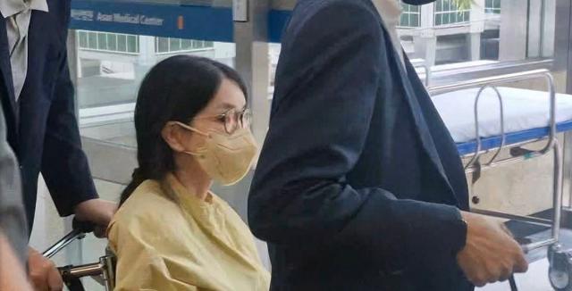 Former first lady Kim Keon Hee leaves Asan Medical Center in southern Seoul in a wheelchair pushed by former President Yoon Suk Yeol on June 27 2025 Yonhap