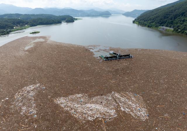 PHOTOS: Post-flood fight against floating waste