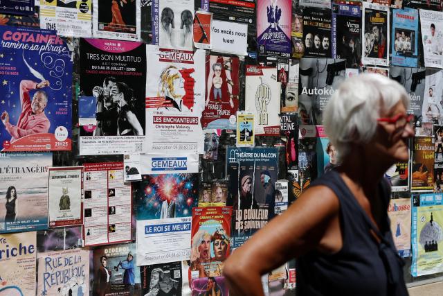 A woman stands in front of play posters during the Avignon Festival in Avignon France on July 16 2025 REUTERS-Yonhap