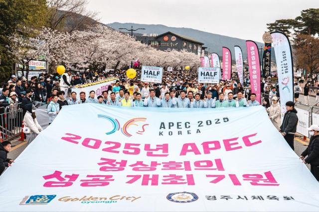 2025년 APEC 정상회의 성공 개최를 기원하며 열린 경주 벚꽃마라톤대회에서 참가자들이 지난 4월 6일 보문단지 일원에서 대형 현수막을 펼쳐 응원의 메시지를 전하고 있다사진경주시