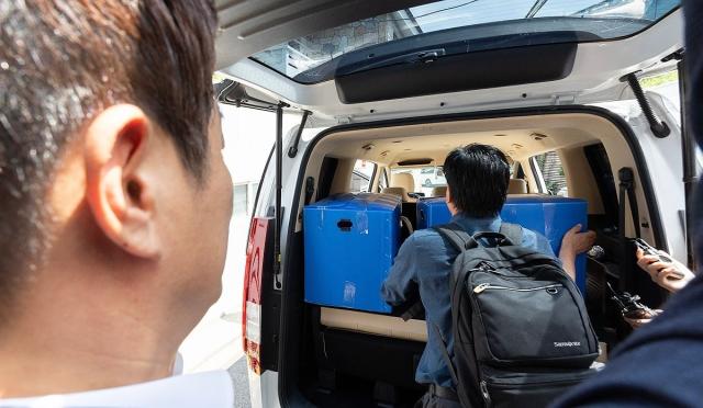 Prosecutors load seized items into a vehicle after raiding former Prime Minister Han Duck-soo’s residence in central Seoul on July 24 2025 Yonhap