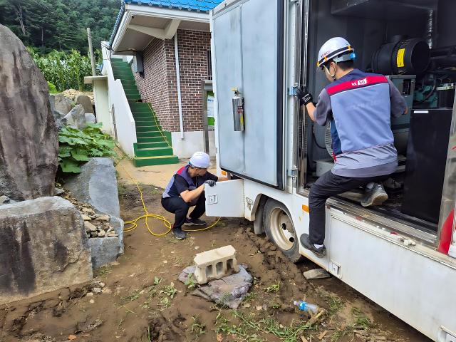 KT 직원들이 지난 23일 가평 수해 지역에 이동형 발전차를 지원하고 있다사진KT