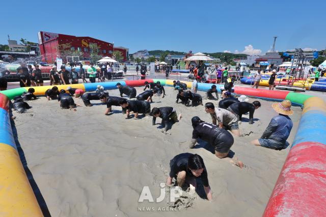 2025년 7월 27일 충남 보령에서 열린 머드축제에서 사람들이 머드풀에서 바둑돌을 찾고있다