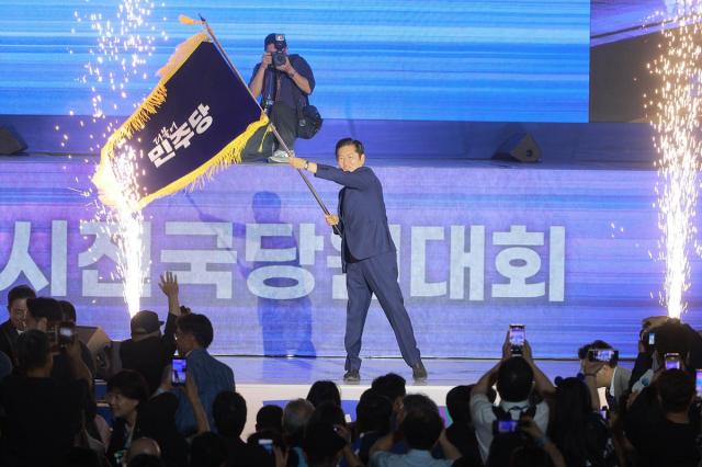 정청래 더불어민주당 신임 당대표가 2일 오후 고양 킨텍스에서 열린 전국당원대회에서 김병기 당대표 직무대행 겸 원내대표로부터 받은 당기를 흔들고 있다 사진유대길 기자 dbeorlf123ajunewscom