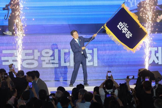 정청래 더불어민주당 신임 당대표가 2일 오후 고양 킨텍스에서 열린 전국당원대회에서 김병기 당대표 직무대행 겸 원내대표로부터 받은 당기를 흔들고 있다 사진유대길 기자 dbeorlf123ajunewscom