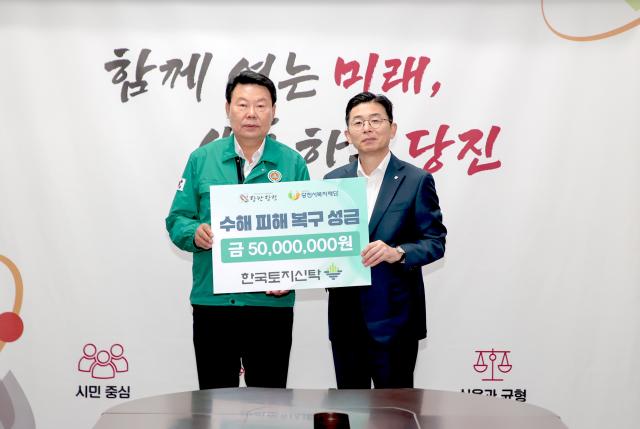 김성진오른쪽 한국토지신탁 대표이사가 4일 당진시청 접견실에서 오성환 시장에게 수해 피해 복구 성금 5000만원을 기탁한 후 기념 사진을 찍고 있다 사진 한국토지신탁