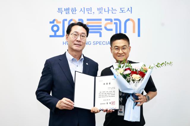 정명근 화성특례시장좌과 정동헌 주무관우이 기념촬영을 하고 있다 사진화성시