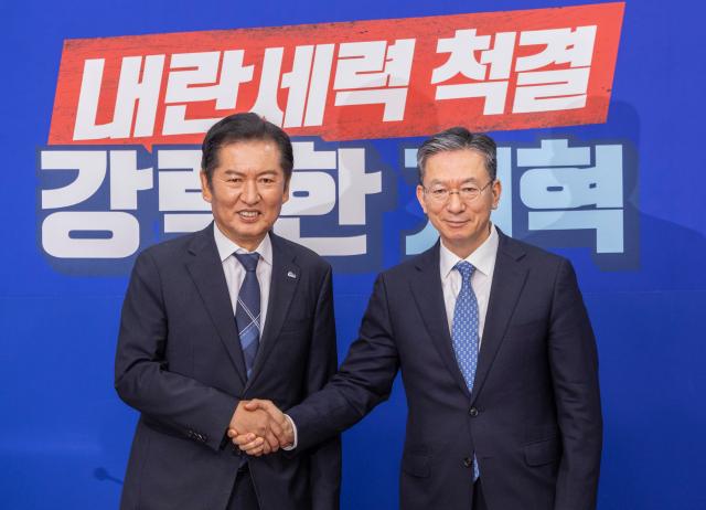 정청래 대표왼쪽와 정성호 법무부 장관이 6일 국회에서 만나 서로 악수하고 있다