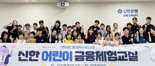 지난 9일 서울 중구 명동 신한 익스페이스에서 열린 신한 어린이 금융체험교실에 참석한 어린이들과 신한은행 금융교육 강사들이 기념 촬영을 하고 있는 모습 사진신한금융그룹
