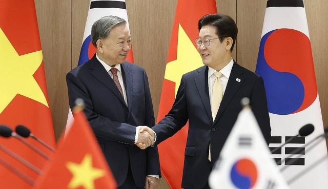 President Lee Jae-myung right shakes hands with Vietnamese Communist Party General Secretary To Lam ahead of the summit at the presidential office in Yongsan Seoul on Aug 11 2025 Yonhap