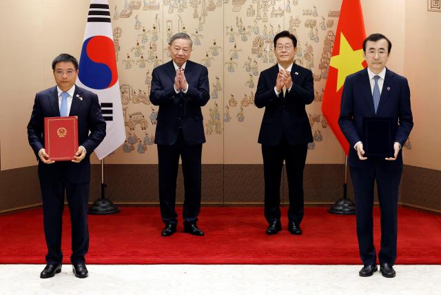 이세훈 금융감독원장 대행과 응우옌 반 탕 베트남 재무부 장관이 11일 서울 용산 대통령실 청사에서 이재명 대통령과 또 럼 베트남 당 서기장이 임석한 가운데 열린 양해각서MOU 서명식에서 금융감독당국 간 협력 MOU에 서명 뒤 기념 촬영을 하고 있다 사진대통령실통신사진기자단·연합뉴스
