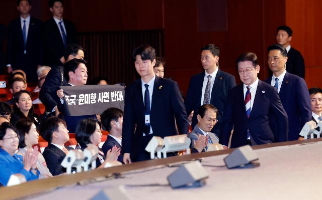안철수 국민의힘 의원이 15일 서울 세종문화회관에서 열린 80주년 광복절 경축식에서 이재명 대통령이 경축사를 마치고 자리로 향할 때 조국·윤미향 사면 반대라는 문구가 적힌 펼침막을 들어보이고 있다 사진연합뉴스