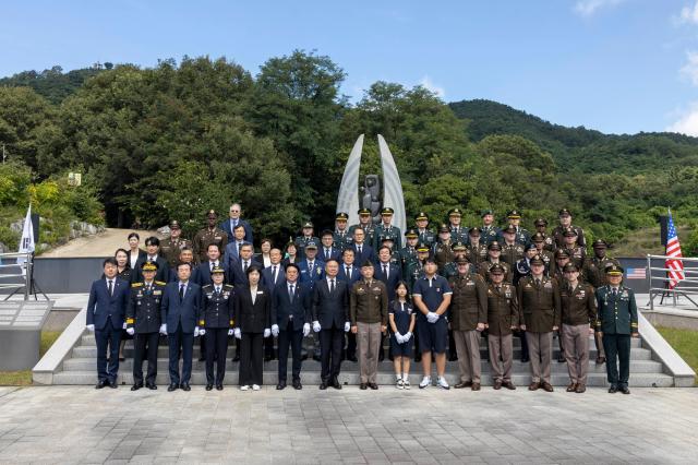합동참배후 김재욱 칠곡군수맨 앞줄 왼쪽 일곱번째 및 칠곡군 관계자들과 러셀 캠프캐롤 6병기대대장맨 앞줄 오른쪽 여덟번째  및 장병들이 기념촬영 하고 있다 칠곡군
