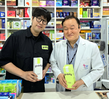 폴리페놀 팩토리의 탈모 방지를 돕는 헤어케어 브랜드 그래비티가 약국에 입점했다 경기 부천 제일큰약국 지문철 약사오른쪽와 그래비티 관계자가 기념촬영을 하고 있다 사진폴리페놀 팩토리