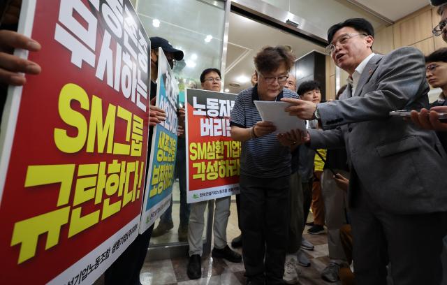 김영훈 고용노동부 장관이 12일 양경수 민주노총 위원장과의 간담회를 위해 서울 중구 민주노총 건물로 들어가며 건설노조의 요구안을 전달받고 있다 사진연합뉴스
