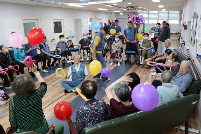 어르신들이 봉사단원들과 함께 풍선 배드민턴을 즐기고 있다 사진광양제철소