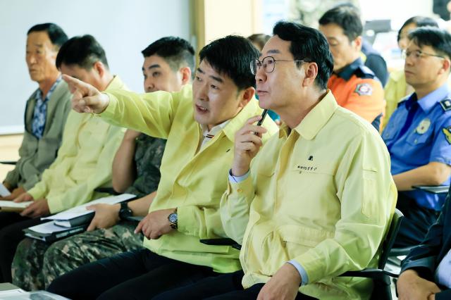 정명근 화성특례시장과 배정수 화성특례시의회 의장이 전시종합상황실의 상황보고와 관련하여 의견을 나누고 있다 사진화성시
