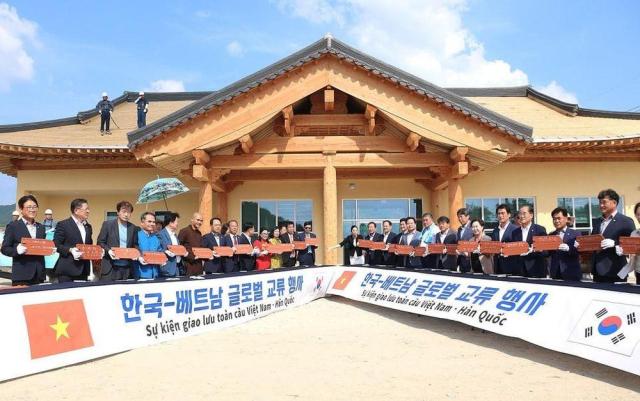 ác đại biểu Hàn-Việt ký lên ngói để cất nóc Nhà Cộng đồng tại Bonghwa ẢnhTTXVN