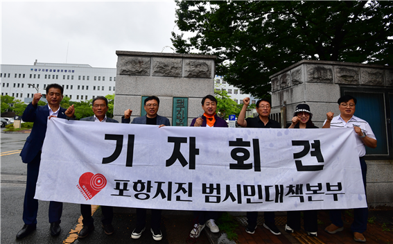 포항지진 범대본 회원들이 26일오후 2시 포항지원 정문 앞에서 기자회견을 열고 ‘촉발지진 책임자 처벌을 촉구’하는 구호와 함께 촉발지진을 방지하지 못한 “고위 공직자들도 법정에 세워라”라고 외치고 있다 사진포항지진 범시민대책본부
