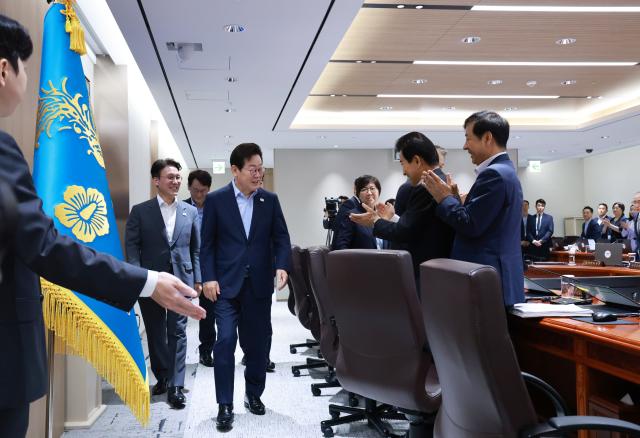 이재명 대통령이 29일 서울 용산 대통령실 청사에서 열린 임시 국무회의에 국무위원들의 기립박수를 받으며 입장하고 있다