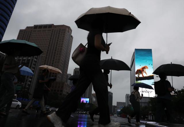 Civilians walk to workplaces as rain pours above in central Seoul Sept 4 2025 Yonhap