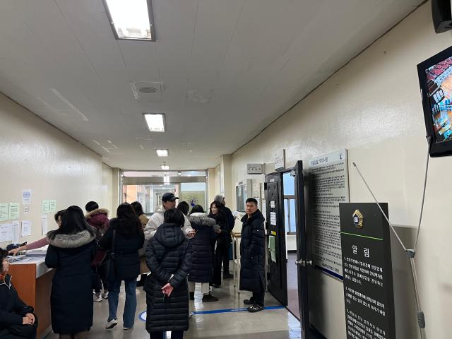 같은 날 법정 입구 앞 복도 입찰이 시작되고 경매 참기자들이 입찰 봉투를 수령받은 뒤 복도에 모여있는 모습 사진한승구 수습기자 
