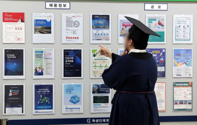  2025년 여름 학위수여식이 열린 서울 종로구 성균관대학교에서 한 졸업생이 취업 정보 게시판을 살펴보고 있다