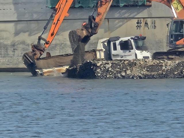 지난 16일 울릉공항 건설 현장에서 15톤 덤프트럭이 바다로 추락하는 사고가 발생해 굴삭기가 구조 활동을 펼치고 있다 사진독자제공