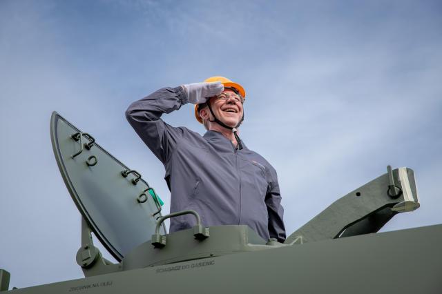 Brian Smith, a former U.S. soldier, poses on a K9 howitzer during the event at Hanwha Aerospace's Changwon plant on Sept. 19.