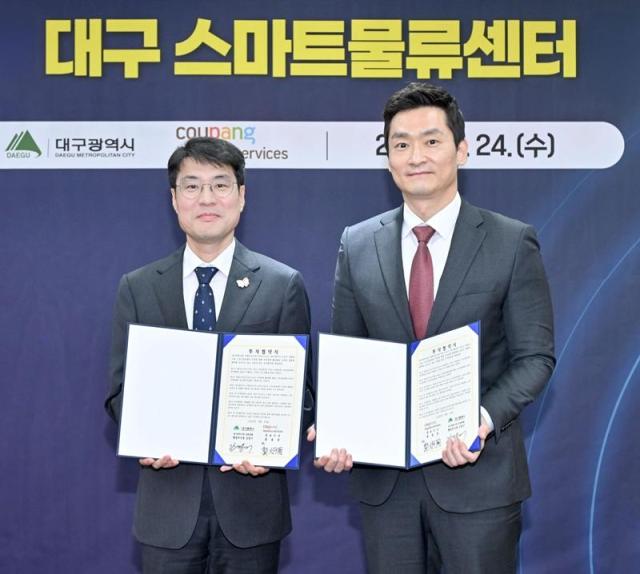 김정기 대구광역시장 권한대행좌측과 곽형주 쿠팡로지스틱스서비스 상무가 지난 24일 오후 대구광역시청에서 열린 쿠팡로지스틱스서비스 대구 스마트물류센터 신설 투자협약식에서 협약서를 들고 사진 촬영을 하고 있다 사진쿠팡 