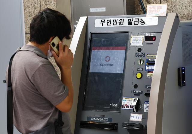 화재에 먹통 된 무인민원발급기…애타는 시민 사진은 27일 서울 시내 한 지하철역에 설치된 무인민원발급기에서 한 시민이 서류가 발급되지 않자 통화를 하고 있다사진연합뉴스