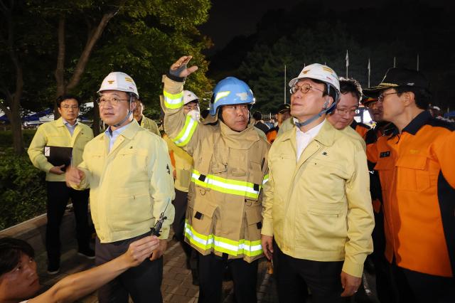 Prime Minister Kim Min-seok right and Interior Minister Yun Ho-jung left are briefed by firefighters while visiting the site of the fire at the National Information Resources Service Sept 27 Yonhap