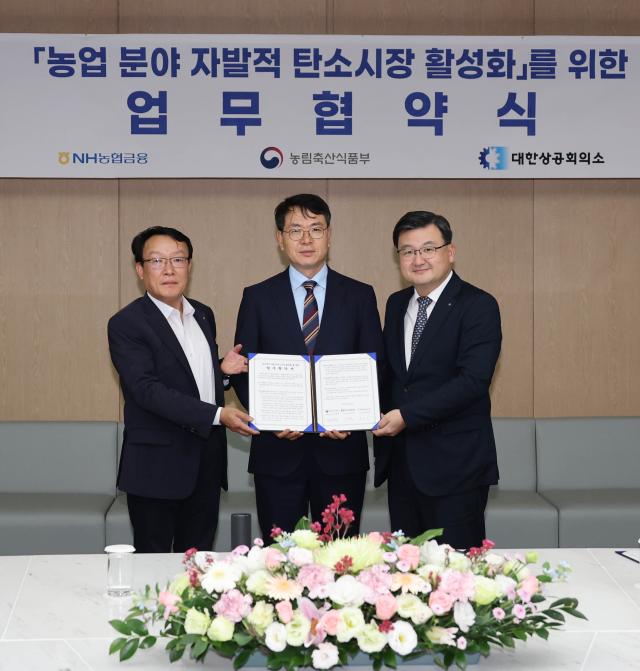 지난 26일 서울 중구 대한상공회의소에서 열린 농업분야 탄소크레딧 활성화 및 ESG 상생협력 업무협약에서 박종국 NH농협금융지주 ESG전략부장왼쪽 김정욱 농림축산식품부 농식품혁신정책관농업혁신정책실장 직무대리·가운데 조영준 대한상공회의소 지속가능경영원장오른쪽이 기념촬영을 하고 있는 모습 사진농협금융
