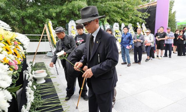 Participants lay flowers at the joint memorial service for forced mobilization victims during the Japanese colonial rule at the memorial park of the National Memorial Museum of Forced Mobilization in Nam-gu Busan Sept 29 2025 Yonhap