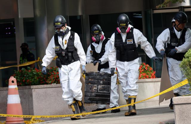 Police officials move burnt lithium-ion batteries from the uninterruptible power supply system at the National Information Resources Service in Daejeon Yonhap