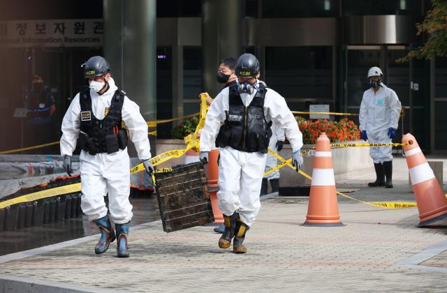 Investigators move lithium-ion batteries from an uninterruptible power supply UPS after completing stabilization work at the fire site of the National Information Resources Service in Yuseong District Daejeon on September 30 YONHAP