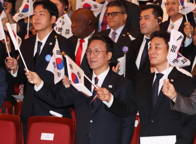 김민석 국무총리가 3일 서울 종로구 세종문화회관에서 열린 개천절 경축식에서 참석자들과 만세삼창을 한 뒤 태극기를 흔들고 있다 사진연합뉴스