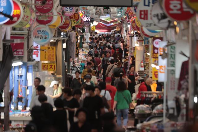 Shoppers browse through a traditional market in Seoul ahead of Chuseok the Korean autumn thanksgiving holiday on October 2 2025 YONHAP