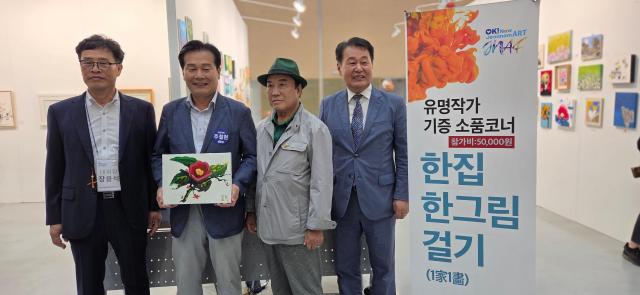 주철현 의원이 개막식 마지막 순서인 전시장 관람과 한집 한그림 기증 이벤트에서 작품을 구입하고 기념사진을 찍고 있다 사진박기현 기자