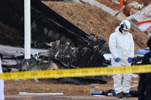A rescue worker looks at debris at Muan International Airport in South Jeolla Province on Dec 29 2024 after a fatal plane crash Yonhap