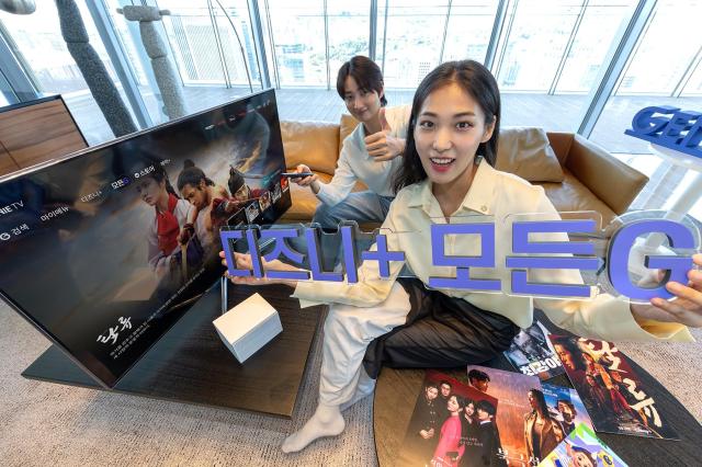 T가 실시간 채널과 VOD 글로벌 OTT를 통합 제공하는 IPTV 요금제 ‘지니 TV 디즈니+ 모든G’를 17일 출시한다고 밝혔다 사진은 모델들이 ‘모든G 전용 메뉴’ 화면 앞에서 ‘지니 TV 디즈니+ 모든G’를 소개하고 있다사진KT