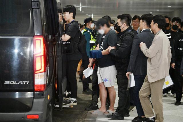 캄보디아 온라인 사기에 가담해 구금된 한국인들이 18일 오전 인천국제공항 제2터미널을 통해 송환돼 호송차에 오르고 있다 이날 송환에는 경찰 호송조 190여명이 투입됐다 20251018 사진연합뉴스 공동취재