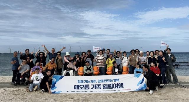 고양시덕양행신장애인주간보호센터 및 뇌병변 이용인과 보호자가 제주도 해변에서 기념사진을 찍고 있다 사진혼다코리아