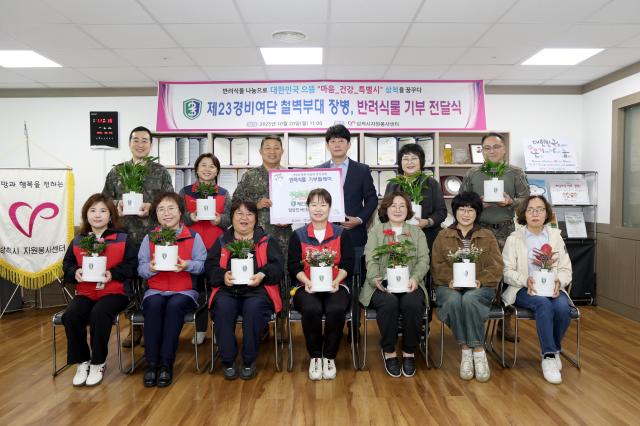 20일 육군 23경비여단장이 ‘오늘의 기부’ 행사로 모은 기부금으로 구매한 ‘반려식물’ 23개를 삼척시자원봉사센터에 전달하고 있다 사진육군 23경비여단