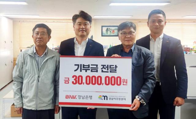 홍응일 BNK경남은행 상무왼쪽 두 번째가 이철승 경남이주민노동복지센터 대표에게 기부금 기탁 증서를 전달하고 있다 사진경남은행

