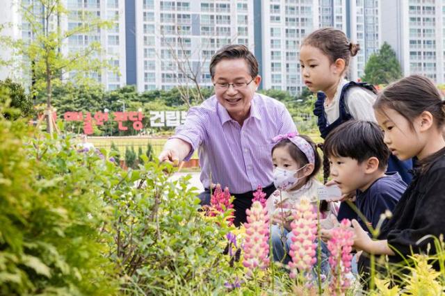 최호권 영등포구청장이 서울 영등포구 문래동 꽃밭정원에서 어린이들에게 초화류를 설명하고 있다 사진영등포구