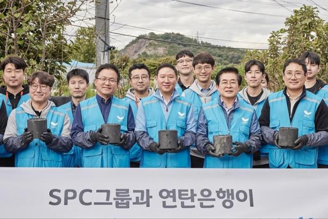 SPC그룹 임직원들이 22일 서울 서초구 전원마을 비닐하우스 단지에서 연탄 배달 봉사활동을 진행하고 기념촬영을 하고있다 사진SPC그룹