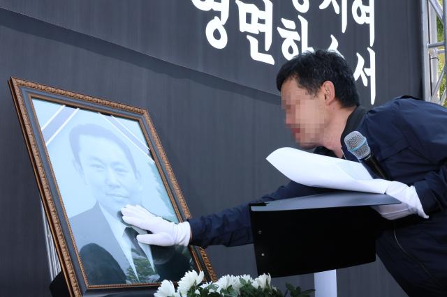 지난 6월 18일 오전 충남 태안군 태안화력발전소 앞에서 작업 중 숨진 재하청 비정규직 노동자 고故 김충현 씨의 영결식이 엄수되는 가운데 김씨의 친구가 영정사진을 어루만지고 있다 사진연합뉴스