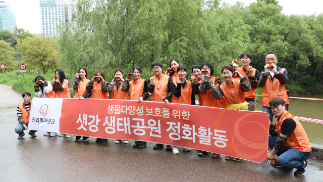 한화투자증권 임직원들이 샛강 흙공 던지기 활동을 마치고 기념촬영을 하고 있다 사진한화투자증권
