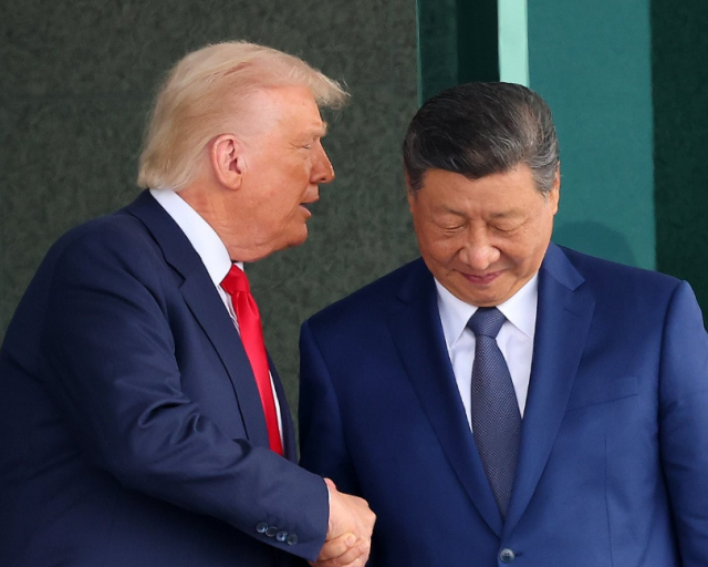US President Donald Trump left and Chinese President Xi Jinping shake hands after a summit at Gimhae Air Base in Busan on Oct 30 2025 Yonhap